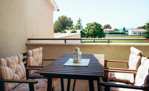 een tafel en stoelen op een balkon met een tafel en een fles bij Apartments with a parking space Fazana - 7205 in Fažana