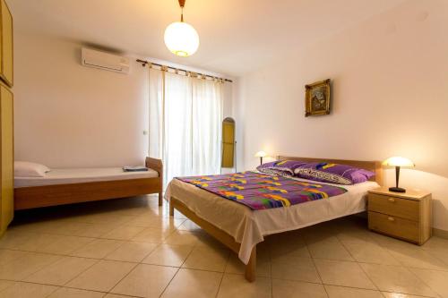 um quarto com uma cama, um sofá e uma janela em Apartment Fazana 7284c em Fažana
