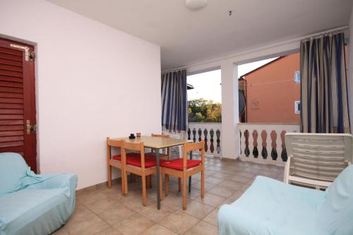 uma sala de estar com uma mesa e cadeiras e um sofá em Apartment Fazana 7284c em Fažana