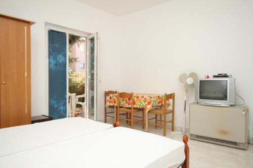 - une chambre avec un lit, une télévision et des chaises dans l'établissement Apartments with a parking space Liznjan, Medulin - 7240, à Ližnjan