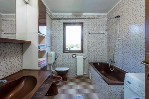 Un baño con bañera, inodoro y lavabo. en Family friendly apartments with a swimming pool Sisan, Medulin - 7243, en Šišan