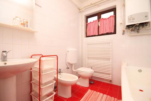 La salle de bains blanche est pourvue de toilettes et d'un lavabo. dans l'établissement Apartments with a parking space Fazana - 7283, à Fažana