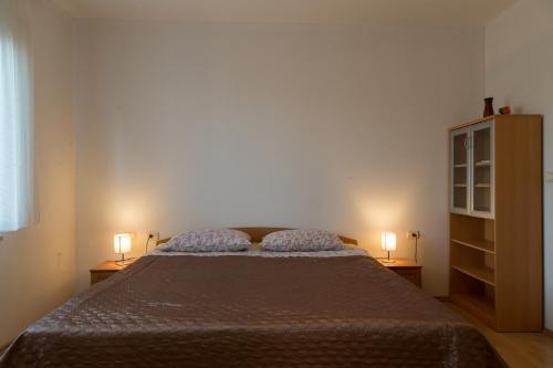 um quarto com uma cama e duas lâmpadas em duas mesas em Apartments with a parking space Peroj, Fazana - 7254 em Vodnjan