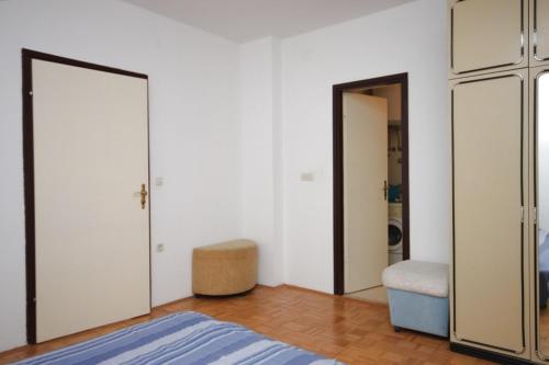 a bedroom with white walls and a bed and a mirror at Apartment Peroj 7254b in Vodnjan