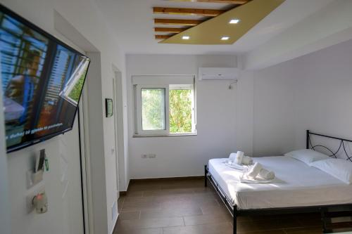 a bedroom with a bed and a flat screen tv at Villa Ani in Borsh