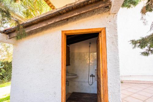 an open door to a bathroom in a house at Sicilian Oasi with exotic garden in Santa Maria Del Focallo