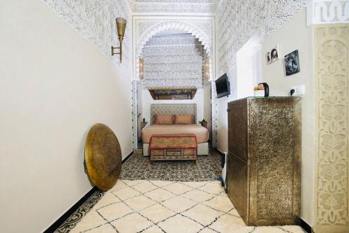 a bedroom with a bed and a dresser in a room at Riad Amelia - Lalla Amelia Room in Tetouan