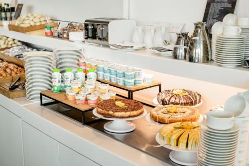 a bakery with cakes and other desserts on a shelf at Copernicus Toruń Hotel in Toruń