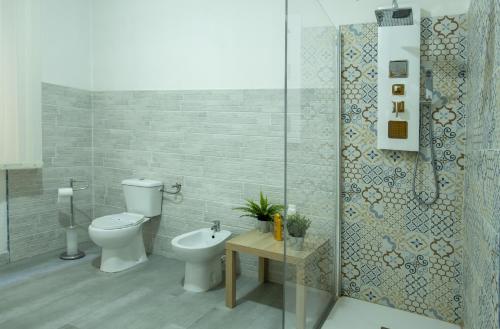a bathroom with a toilet and a sink and a shower at Doctor House standard, suites & luxury rooms in Enna