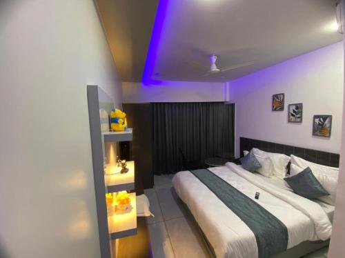 a bedroom with a large bed with a purple ceiling at HOTEL CROWN PALACE in Surat