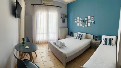 1 dormitorio con paredes azules, 1 cama y 1 mesa en Filoxenia Apartments en Mitilene