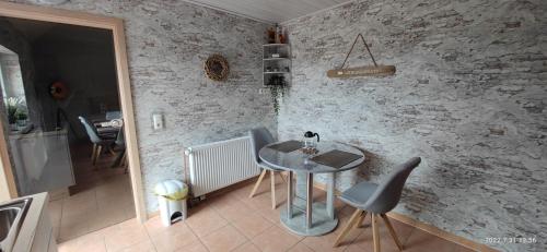 a table and chairs in a room with a brick wall at Galeriehaus "Bootsmann" 