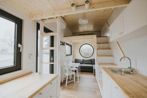 a tiny house with a kitchen and a dining room at Tiny House mit Saunafass und Garten in Brensbach