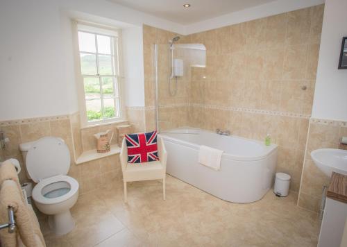 uma casa de banho com uma banheira, um WC e um lavatório. em Crown Cottage Farm em Skipton