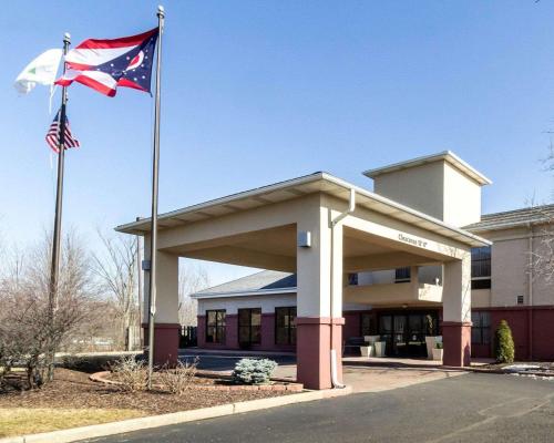 two flags flying in front of a building at Quality Inn & Suites Oakwood Village - Cleveland South in Oakwood