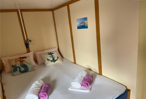 ein Bett mit lila und weißen Handtüchern darauf in der Unterkunft Traditional gulet, cruises & events in Split