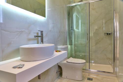 a bathroom with a sink and a shower and a toilet at Katoi Studios Agios Georgios Pagoi in Agios Georgios Pagon