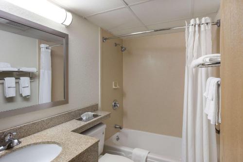 uma casa de banho com um lavatório, um WC e um chuveiro em Quality Inn Central em Albany