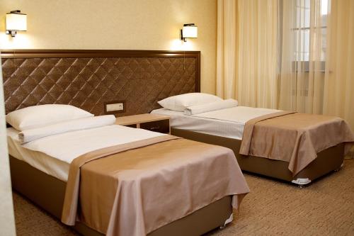 Un pat sau paturi într-o cameră la Troyka Hotel