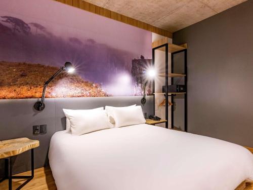a bedroom with a large white bed with two pillows at Novotel Criciuma in Criciúma