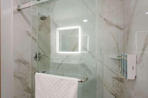 a bathroom with a glass shower with a towel at Best Western Colfax in Colfax