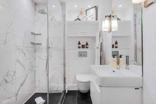 y baño con aseo, lavabo y ducha. en Lady on the Lane- 2 bed Primrose Hill, en Londres