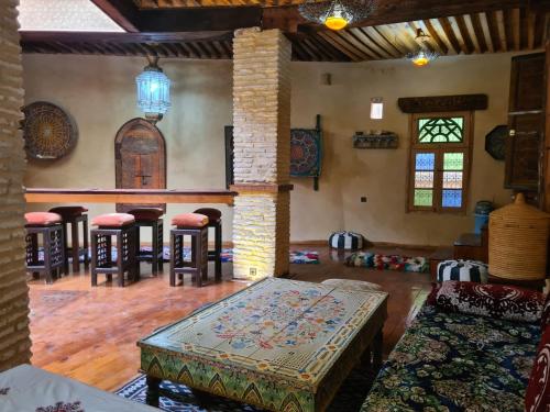 uma sala de estar com mesas e bancos num quarto em Museum House - Dar Melyani em Fez