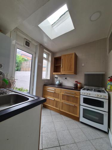 a kitchen with a stove and a sink and a window at Ground floor flat , 31 lena street, easton,bristol avon, uk in Bristol