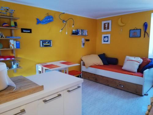 a yellow room with a bed and a desk in it at Ca' Tinetto in Fezzano