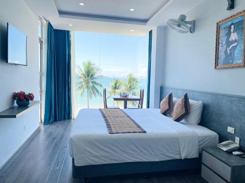 a bedroom with a bed with a view of the ocean at Y Linh Hotel in Quy Nhon