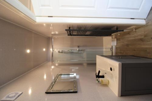 a kitchen with a sink and a ceiling at The Snowdonia Apartments in Llandudno