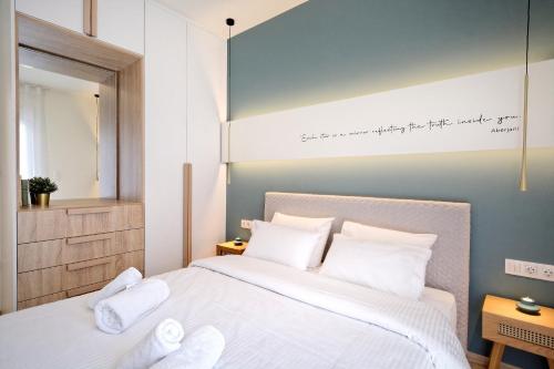 a bedroom with a bed with white sheets and pillows at Eos Residence in Athens