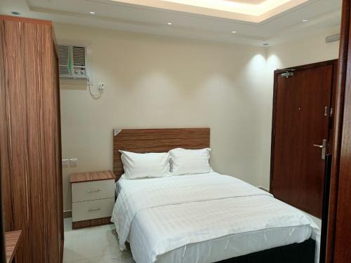 a bedroom with a large bed with a wooden headboard at سجى للوحدات السكنية in Abha
