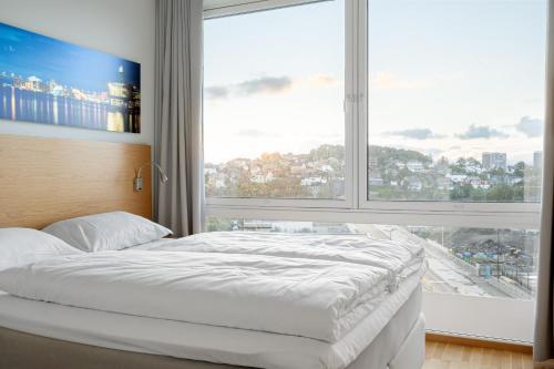 a bed in a room with a large window at Frogner House - Lagårdsveien 115 in Stavanger
