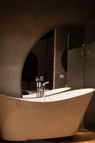 a bathroom with a white tub in front of a mirror at Vila Helen in Voskopojë