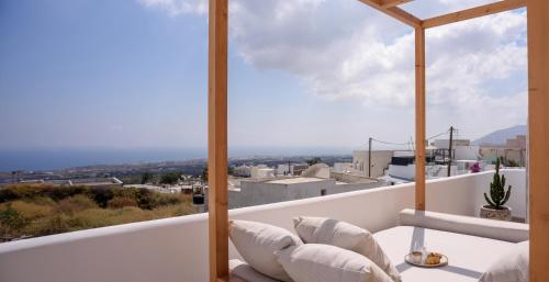 a balcony with white furniture and a view of the city at Lotus Cave Villa in Fira