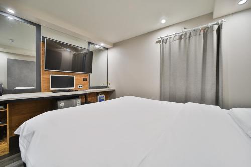 a bedroom with a bed and a flat screen tv at 27 Hotel in Anyang