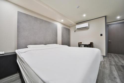 a bedroom with a large white bed in a room at 27 Hotel in Anyang