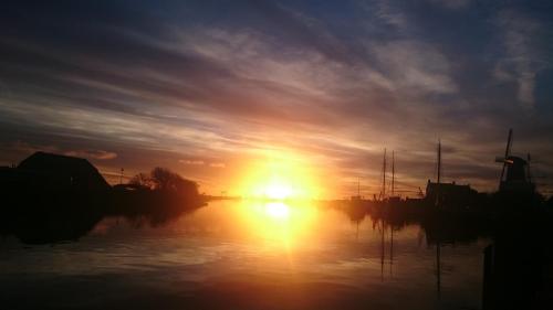 a sunset over a body of water with boats at Zierikzee Appartement ZZ 41 at the Waterfront in Zierikzee