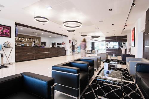 a salon with black chairs and a woman in the background at Westotel Tours Val de Loire in La Ville-aux-Dames