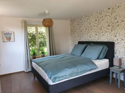 1 dormitorio con 1 cama grande con almohadas azules en Champ Du Bois en Limoise