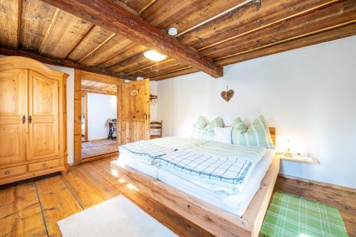 ein Schlafzimmer mit einem großen Bett und Holzdecken in der Unterkunft Ferienhaus Schwöllerbauer in Sankt Martin am Grimming