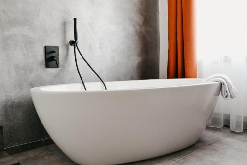 a white bath tub sitting in a bathroom at Nepomuk rooms in Vipiteno