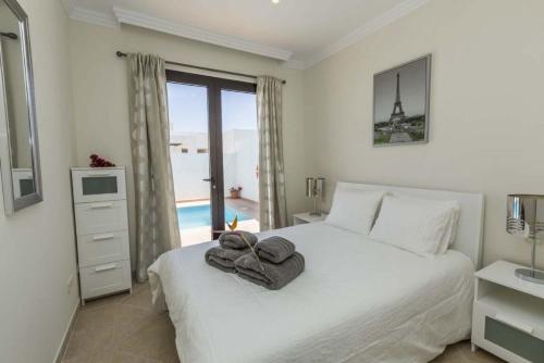 Un dormitorio blanco con una cama con toallas. en Casa Angelita Y Pablo, en Playa Blanca