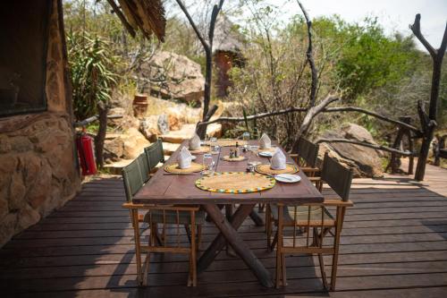 a wooden table with chairs on a wooden deck at Loisaba Star Beds in Tura
