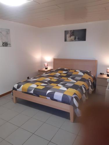 1 dormitorio con 1 cama con manta a cuadros en Gîte des Marais, en Vaux-sur-Sûre