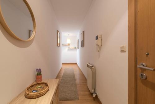 einen Flur mit einem Spiegel und einem Holztisch in der Unterkunft Boavista Boho Apartment w/ Garage in Porto