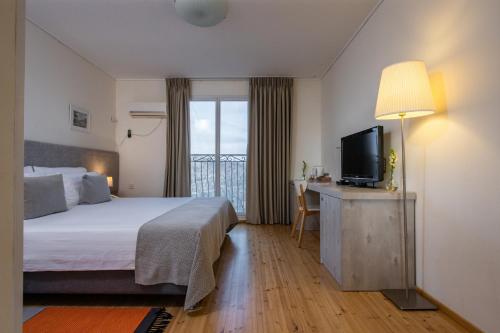 a hotel room with a bed and a television at Logos hotel in Yad Hashmona in Yad Hashmona