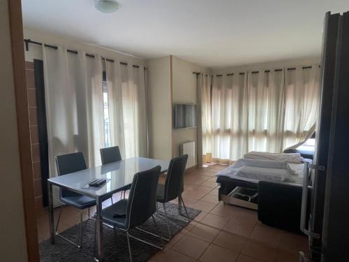 a dining room with a table and chairs and a bed at Apartamentos Boabdil in Sierra Nevada