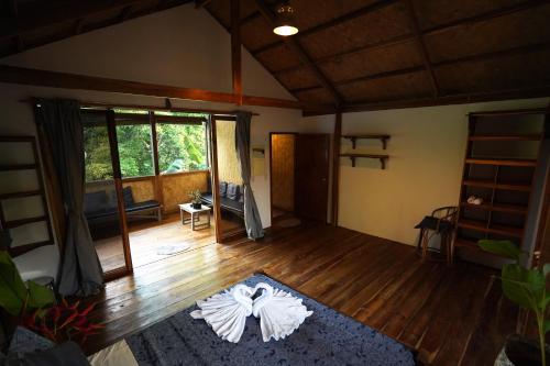 a living room with a large window and a wooden floor at Fisheye Villa in El Nido